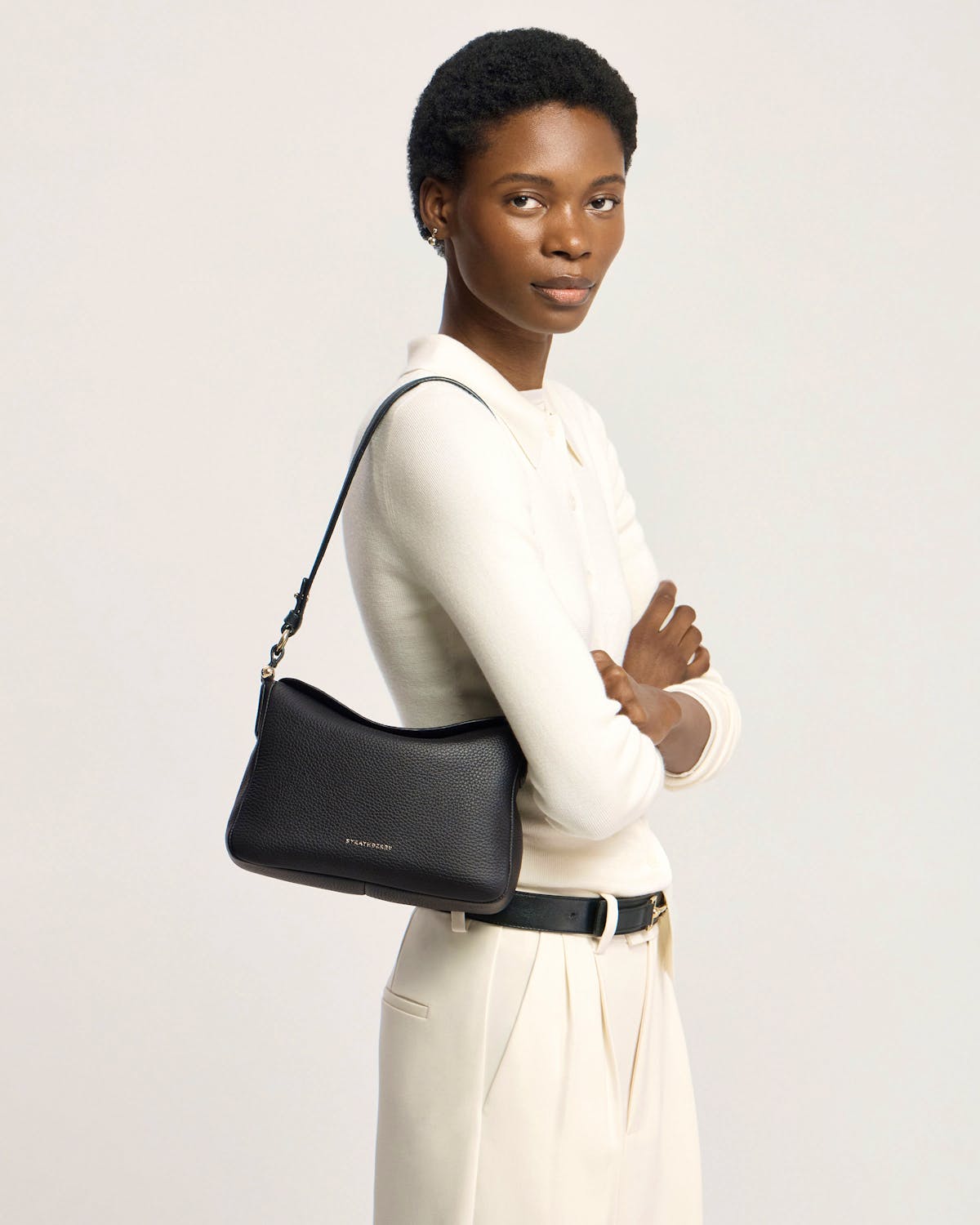 Model wearing a black Sway shoulder bag with visible Strathberry logo.